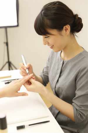 電動ファイルで爪を整えるネイリスト