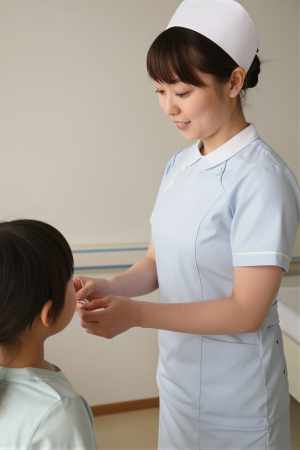 小児病棟で子供にシールを渡す看護師