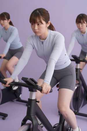 フィットネスバイクで汗を流す女性