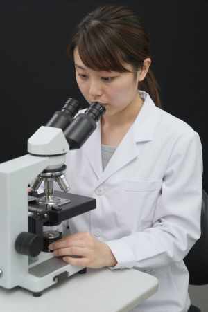 顕微鏡で作業する検査技師