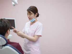 患者に説明する歯科医師