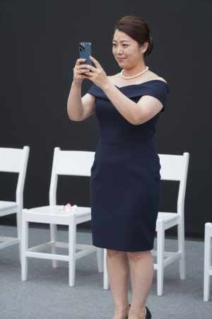 海辺でスマホ撮影を楽しむ女性