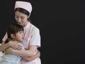 小児病棟で子供を抱きしめる看護師