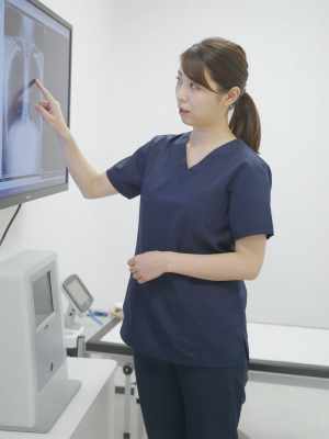 診察室でX線画像を説明する医師