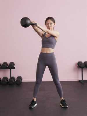 力強くケトルベルスイングをする女性
