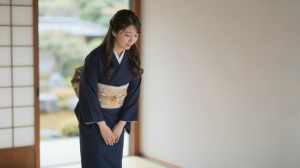 旅館で客を迎える着物姿の女性