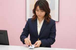 ホテル受付で鍵を整理する女性