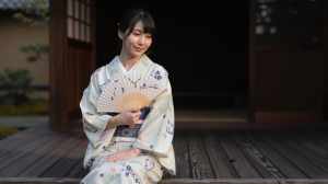 旅館の縁側で夕涼みする女性
