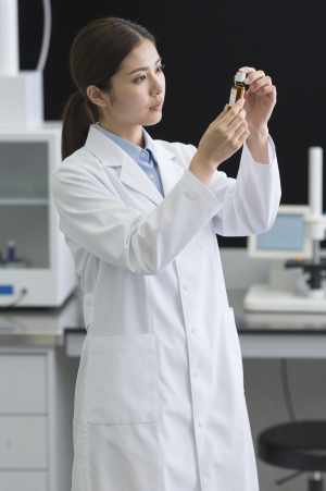 研究所でエッセンシャルオイルを検査する女性研究員