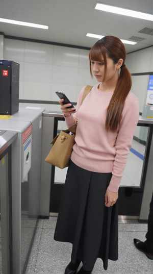 ピンクのセーター姿でバーに佇む女性