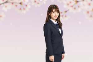桜の背景で微笑む女性ポートレート写真