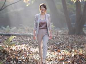 秋の森を歩くスタイリッシュな女性のポートレート