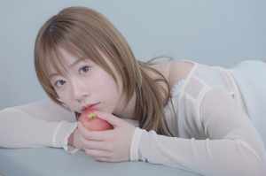 リンゴをかじりポーズの清楚な女性のポートレート