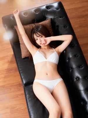 白いビキニを着て、モダンなリビング ルームの黒い革張りのソファに横たわっている若い女...。