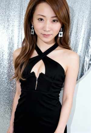 深い V ネックラインと前にジッパーが付いた黒いノースリーブのドレスを着た、長い茶色...。