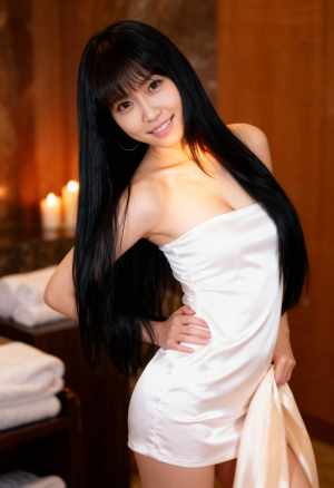 白いストラップレスのドレスを着てスパ環境でポーズをとる若い女性をポートレートアングル...。