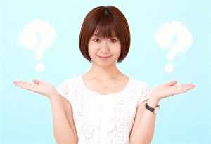 画像の中央に立ち、白いレースのトップと金のネックレスを身に着けたアジア系の若い女性が...。