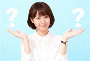 白い襟付きのシャツを着た、ショートボブのヘアカットをしたアジア系の若い女性が、頭の上...。