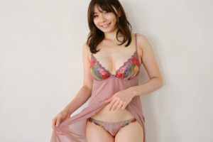 真っ白な壁を背景にフェミニンなランジェリーを着てポーズをとる若い女性を、正面カメラの...。