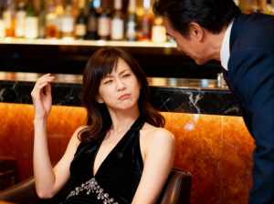バーでの女性と男性の瞑想的なシーンを横から撮影したフォトリアリスティックな写真。
