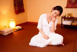 スパのような雰囲気の畳に座る若い女性。