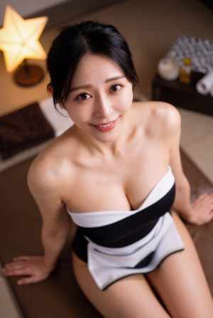 スパの敷物の上に座り、首に白と黒の縞模様のタオルを掛けた女性をローアングルの視点から...。