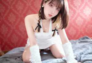柔らかい質感の赤い壁を背景に、ベッドの上でポーズをとる若い女性を正面から写実的に撮影...。