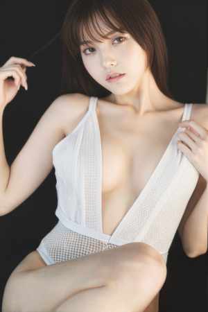 暗い背景に露出度の高い白い衣装を着てポーズをとる若い女性を、クローズアップ カメラ ...。