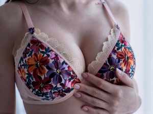 花柄のブラジャーを着けた女性の上半身を正面から、胸を中心にクローズアップした写真です。