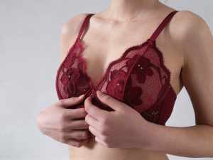 ワインレッドのレースのブラジャーを着けた女性の上半身を中心に、正面からクローズアップ...。