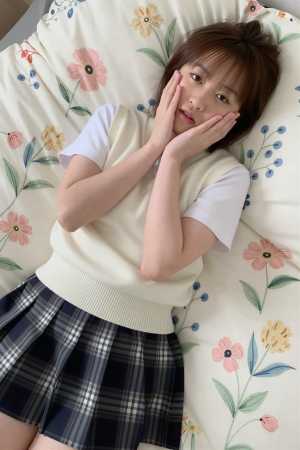 ベッドで白のセーターを着た美女