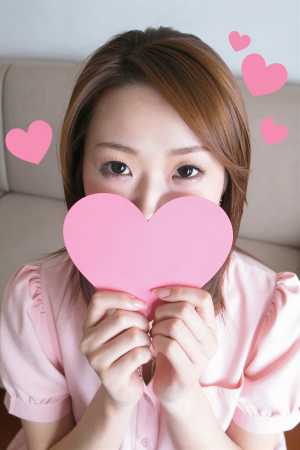 ピンクのブラウス姿でソファに佇む女性