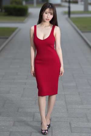 赤のドレス姿で公園に佇む女性