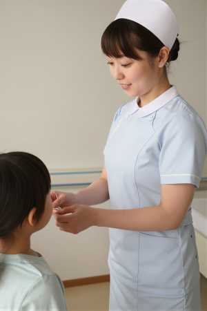 小児病棟で子供にシールを渡す看護師