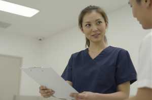 廊下で同僚と話す看護師