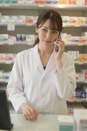 電話対応と品出しをする薬剤師