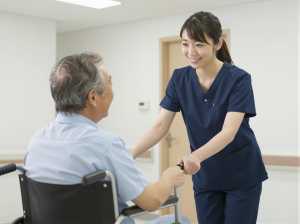 車椅子を押しながら話す看護師