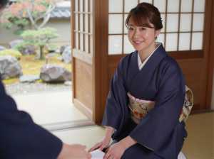 旅館の玄関で履物を整える仲居