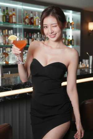 クラブのバーでカクテルを作るドレス嬢