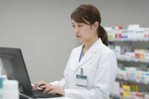 薬局でPC作業する薬剤師