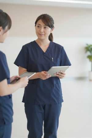 病院ロビーでタブレット操作する医師