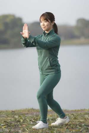 湖畔で太極拳をする女性