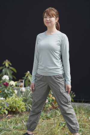 庭でガーデニング前に準備運動する女性