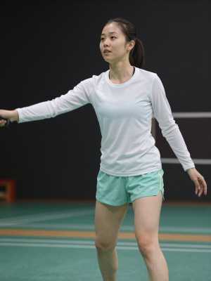 体育館でバドミントンを楽しむ女性