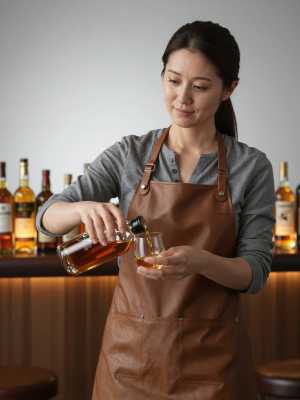 ウィスキーを注ぐ女性バーテンダー