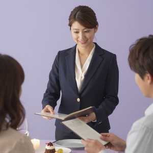 高級レストランでメニューを案内する女性