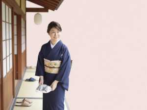 旅館の玄関で履物を整える女性