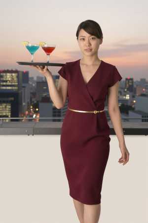 ルーフトップバーでカクテルを運ぶ女性