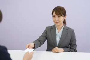 ホテルの受付で鍵を渡す女性