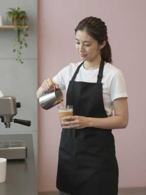 モダンカフェでアイスラテを作る女性